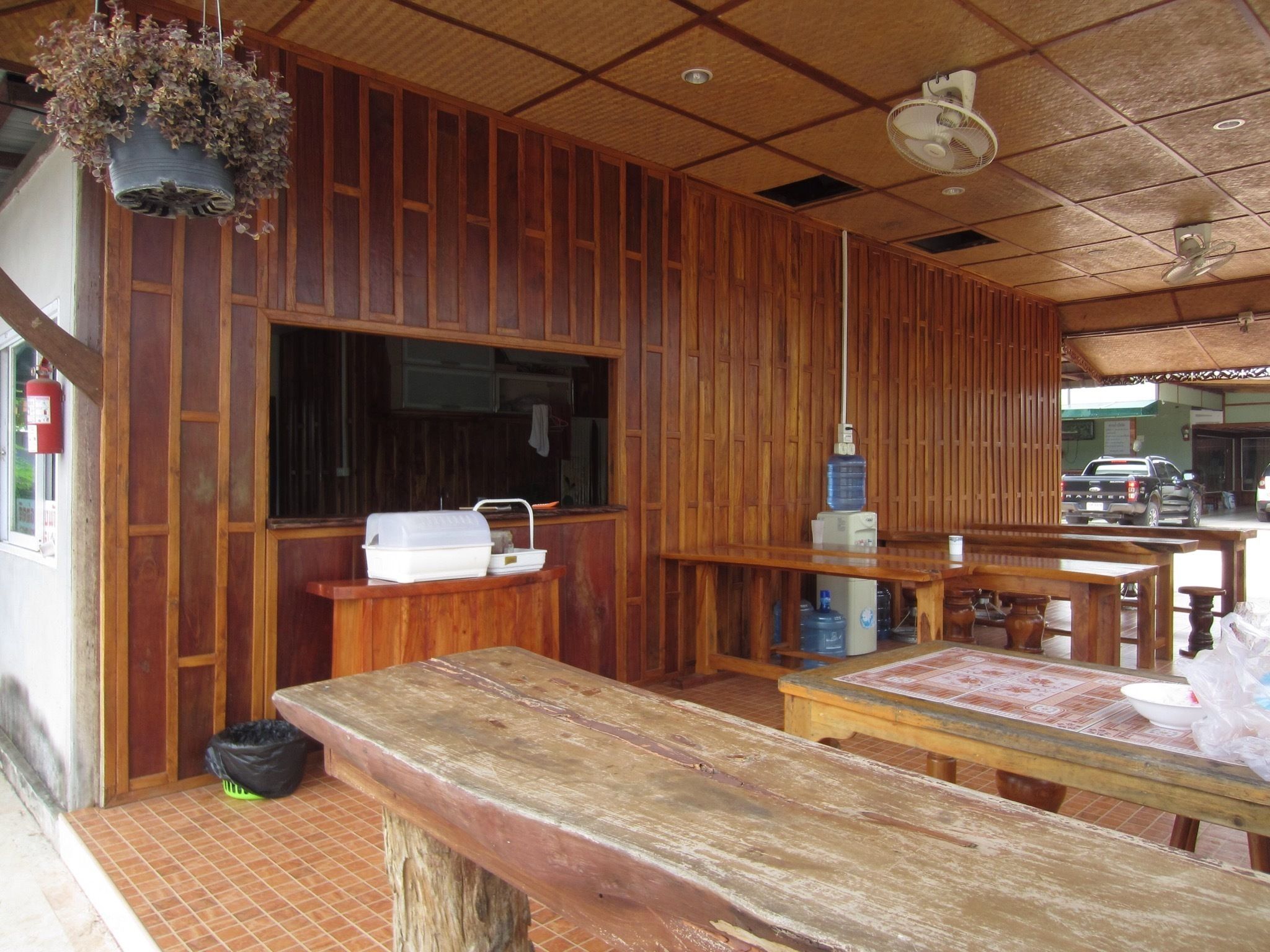A wooden interior with a large window, a sink, and a table with chairs.