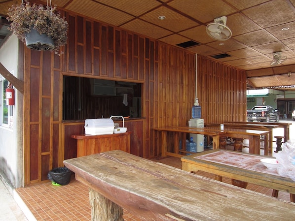 A wooden interior with a large window, a sink, and a table with chairs.