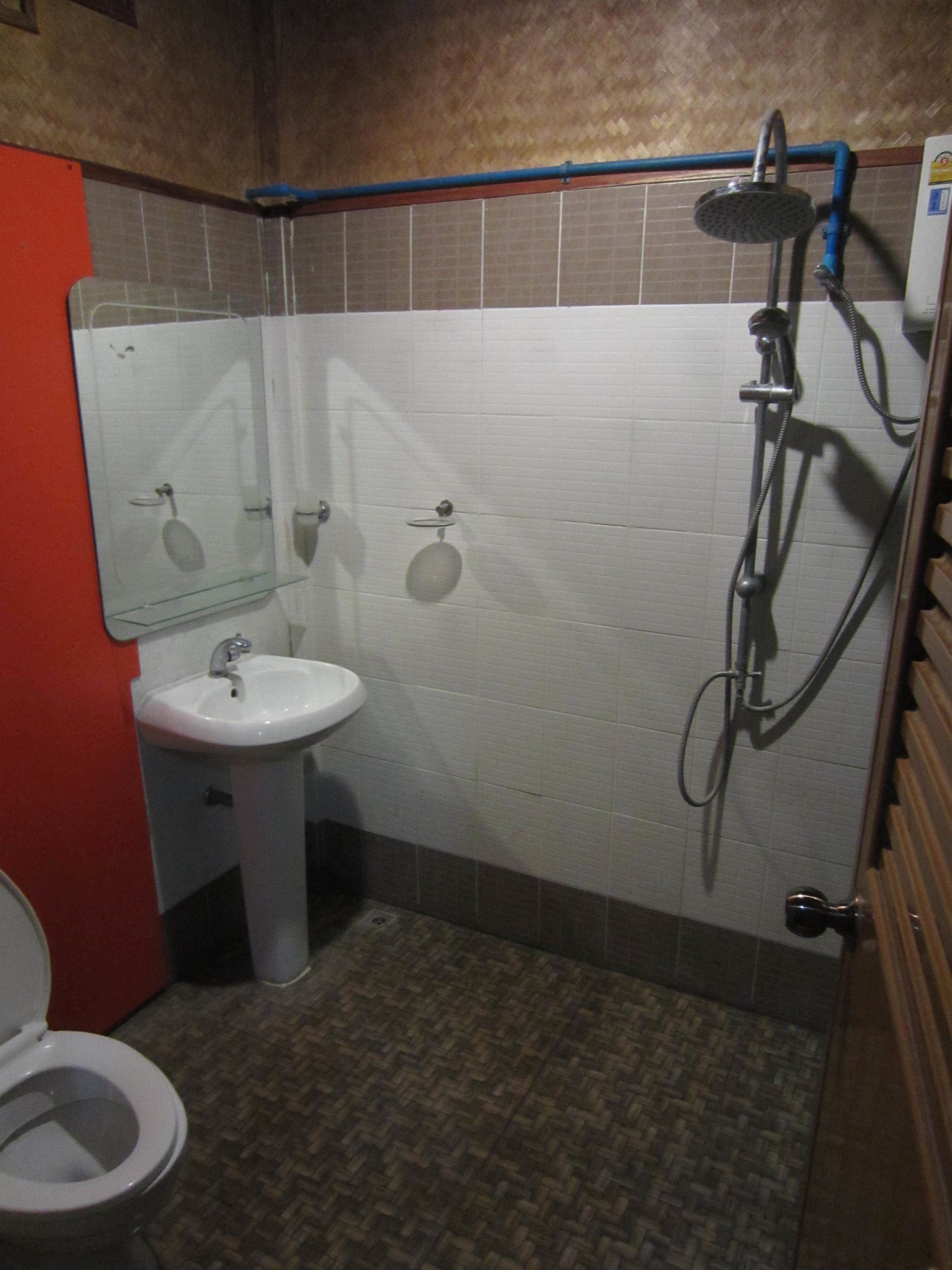 A small bathroom with a toilet, sink, and shower.