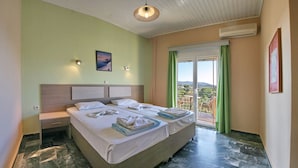 A double bed with a headboard, a nightstand, and a window with a view of the outdoors. - Armonia Studios (Lesvos)