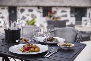 A dining table with plates of food, wine glasses, and cutlery. - Araslöv Golf & Resort (Färlöv)