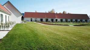 A modern building with a red roof, a well-maintained lawn, and a row of windows. - Araslöv Golf & Resort (Färlöv)
