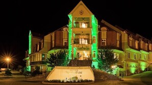 Un hotel de varios pisos con una entrada destacada y una escalera que conduce a la entrada principal.