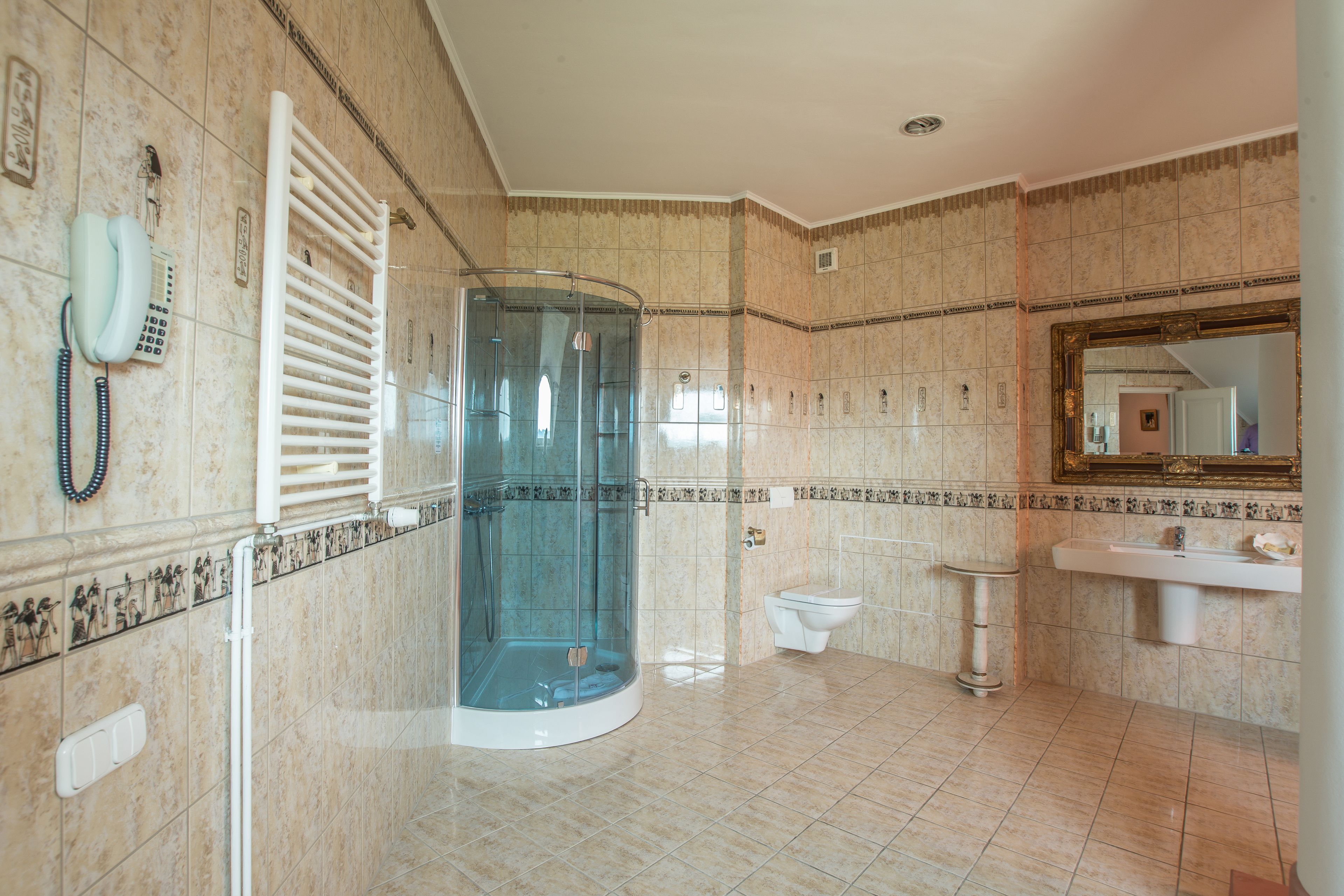 Een badkamer met een douche met glazen wand, een toilet en een wastafel.