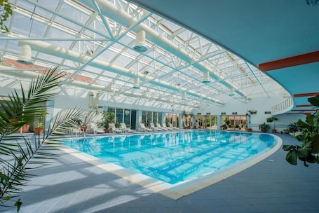 Una piscina techada, sillones reclinables de piscina. Mercure Medias Binderbubi Hotel And Spa