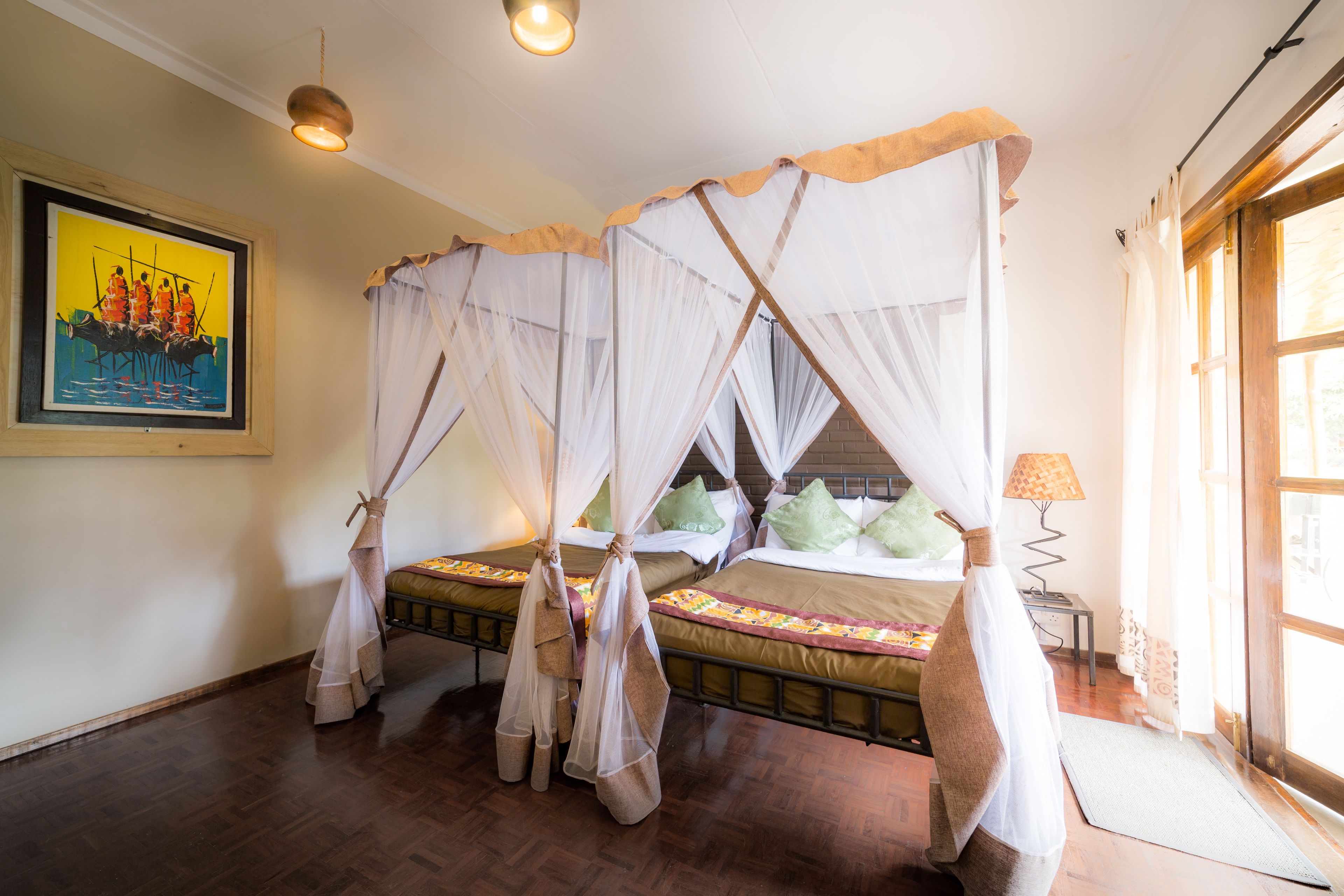 Una habitación con una cama con dosel, un cuadro en la pared y una ventana con cortinas.