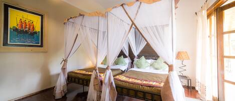 Una habitación con una cama con dosel, un cuadro en la pared y una ventana con cortinas.