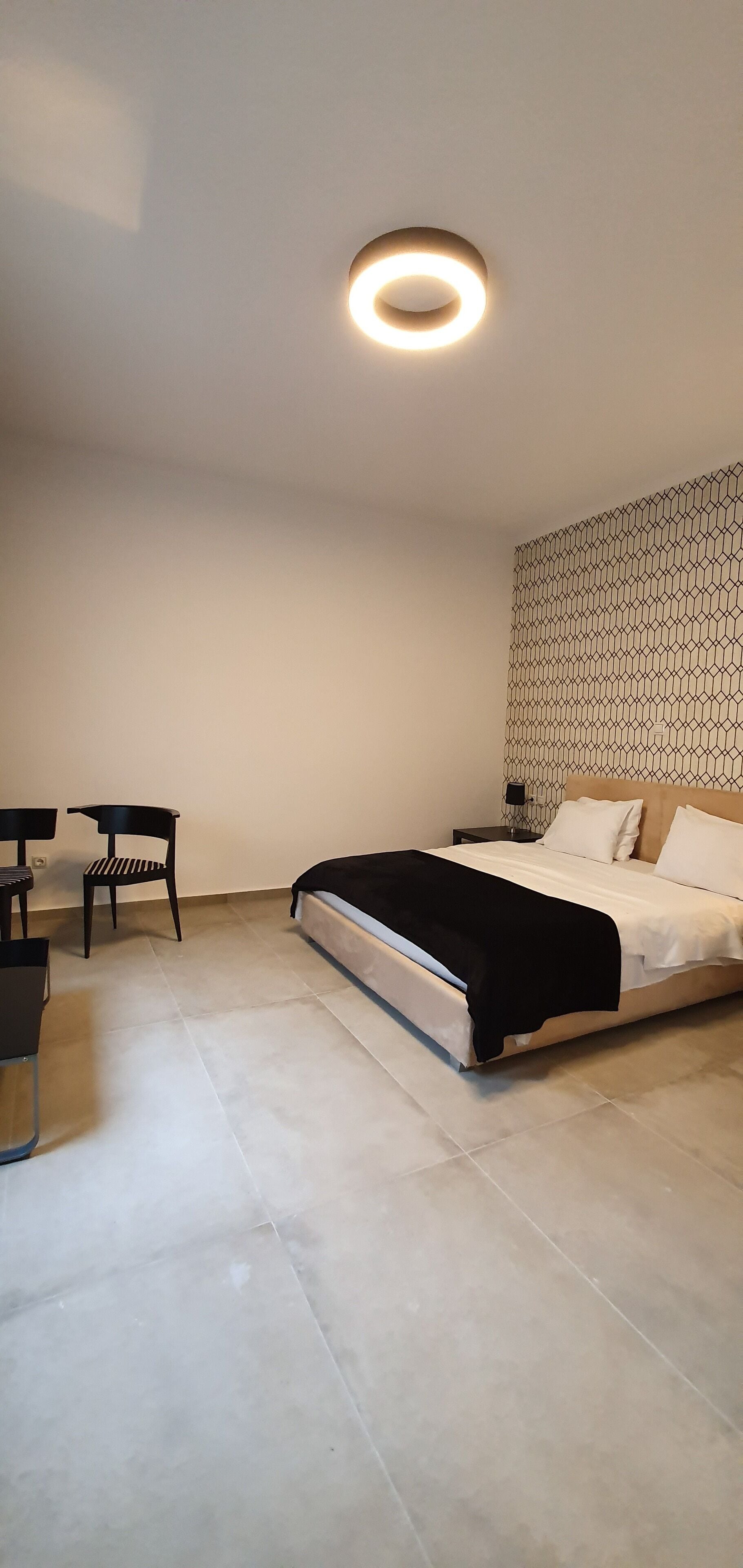A modern bedroom with a bed, a desk, and a chair.