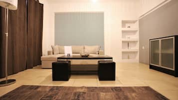 Suite empresarial, 1 habitación | Área de sala de estar | Televisión LED de 25 pulgadas con canales por cable y televisión