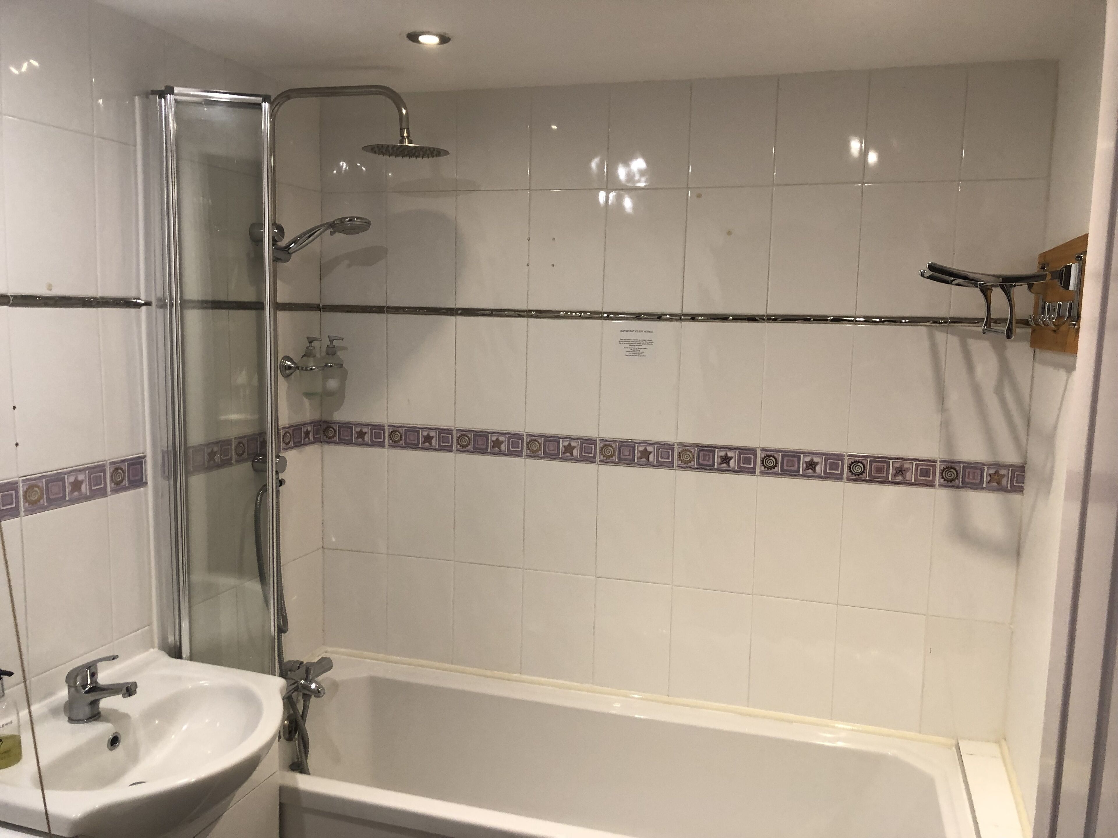 A bathroom with a glass-enclosed shower, a bathtub, and a sink.