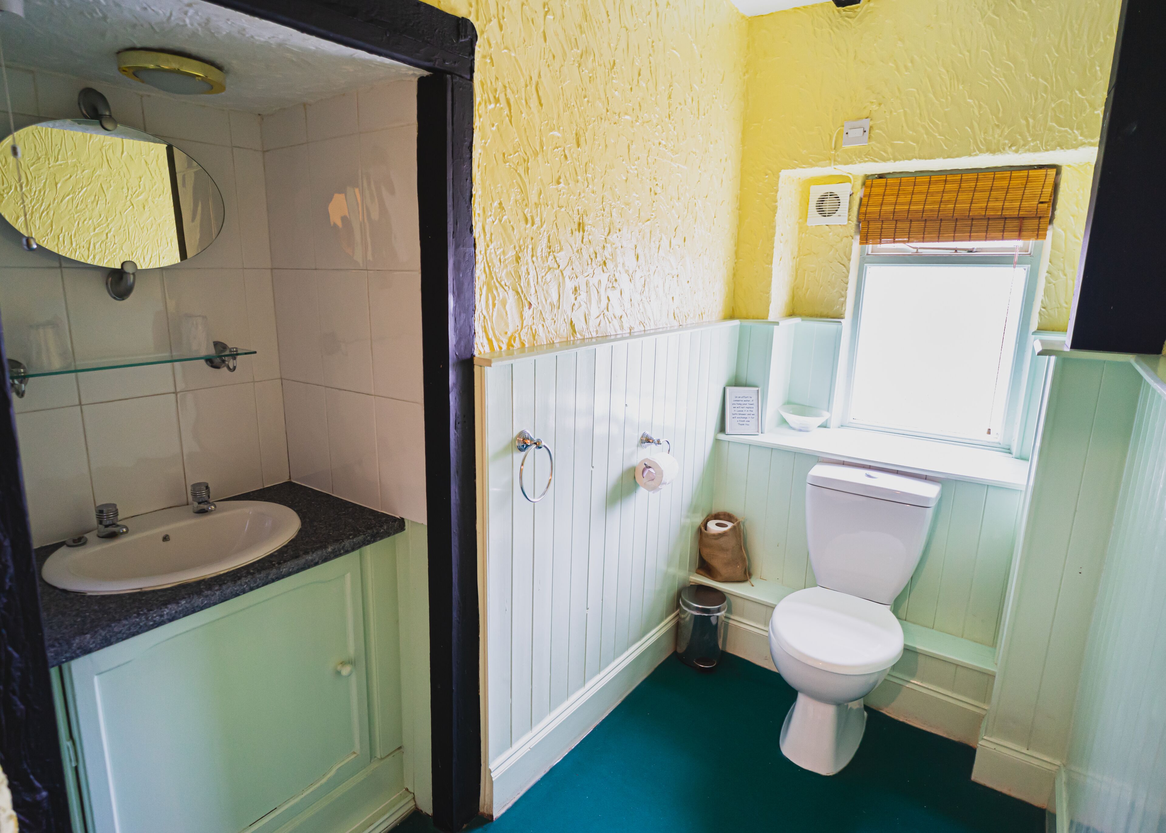 Een badkamer met een wastafel, toilet en spiegel.