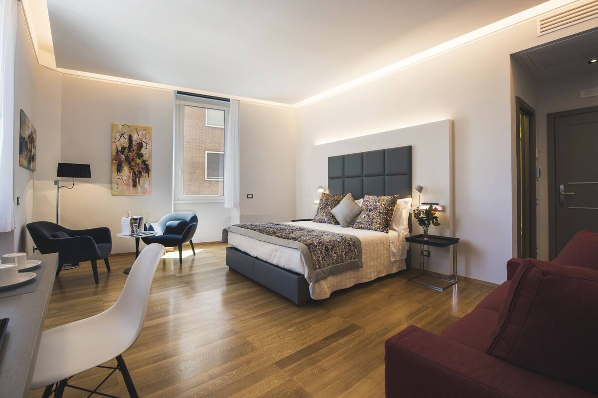 Une chambre à coucher moderne avec un grand lit, un bureau et une chaise.
