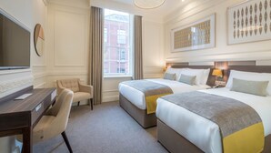 A hotel room with two beds, a desk, a chair, a TV, and a large window with curtains. - Hotel 7 Dublin (Dublin)