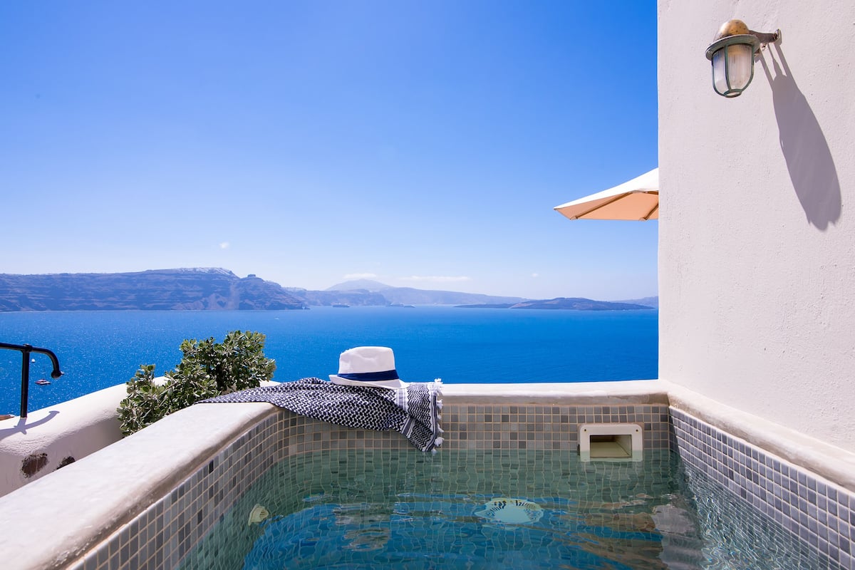 A clear view of a swimming pool with a tiled edge, a white wall, and a hanging hat.