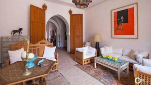Un interior tradicional marroquí con un sofá, una mesita de centro y elementos decorativos.