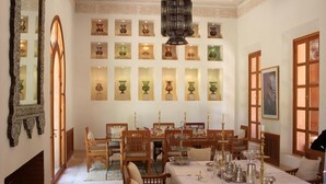 Un comedor con una larga mesa dispuesta para una comida, rodeada de sillas de madera.