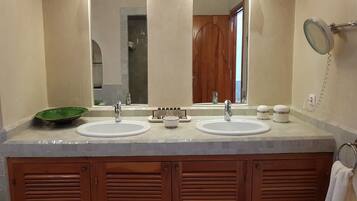 Un baño con dos lavamanos, un espejo y un cuenco verde.