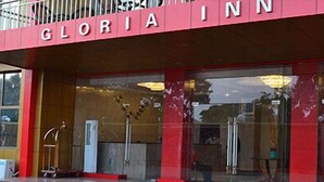The exterior of Gloria Inn with a red awning and large glass windows. - Hotel Gloria Inn (Lubumbashi)