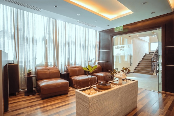Um lobby moderno com sofás de couro, um balcão de recepção e uma área de atendimento.