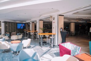 A modern lounge area with seating, a bar, and a television screen. - Best Western Plus Addis Ababa (Addis Ababa)