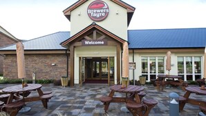 A building with a 'Brewers Fayre' sign, a welcome sign, and multiple picnic tables outside. - Premier Inn Abergavenny (Llanfoist)