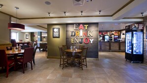 A restaurant with a sign that reads 'EAT DRINK ENJOY' and a wall with a sign stating 'There is no sincerer love of food.' - Premier Inn Abergavenny (Llanfoist)