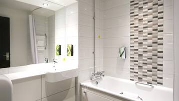 A modern bathroom with a double sink, a shower, and a large mirror.