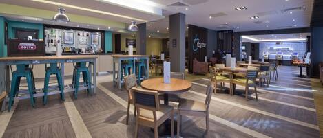 A modern hotel lobby with a bar area, seating arrangements, and a reception desk.