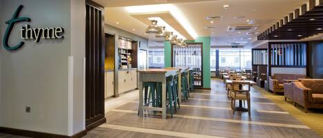 Ein modernes Interieur mit Barbereich, Sitzgelegenheiten und einer Treppe.