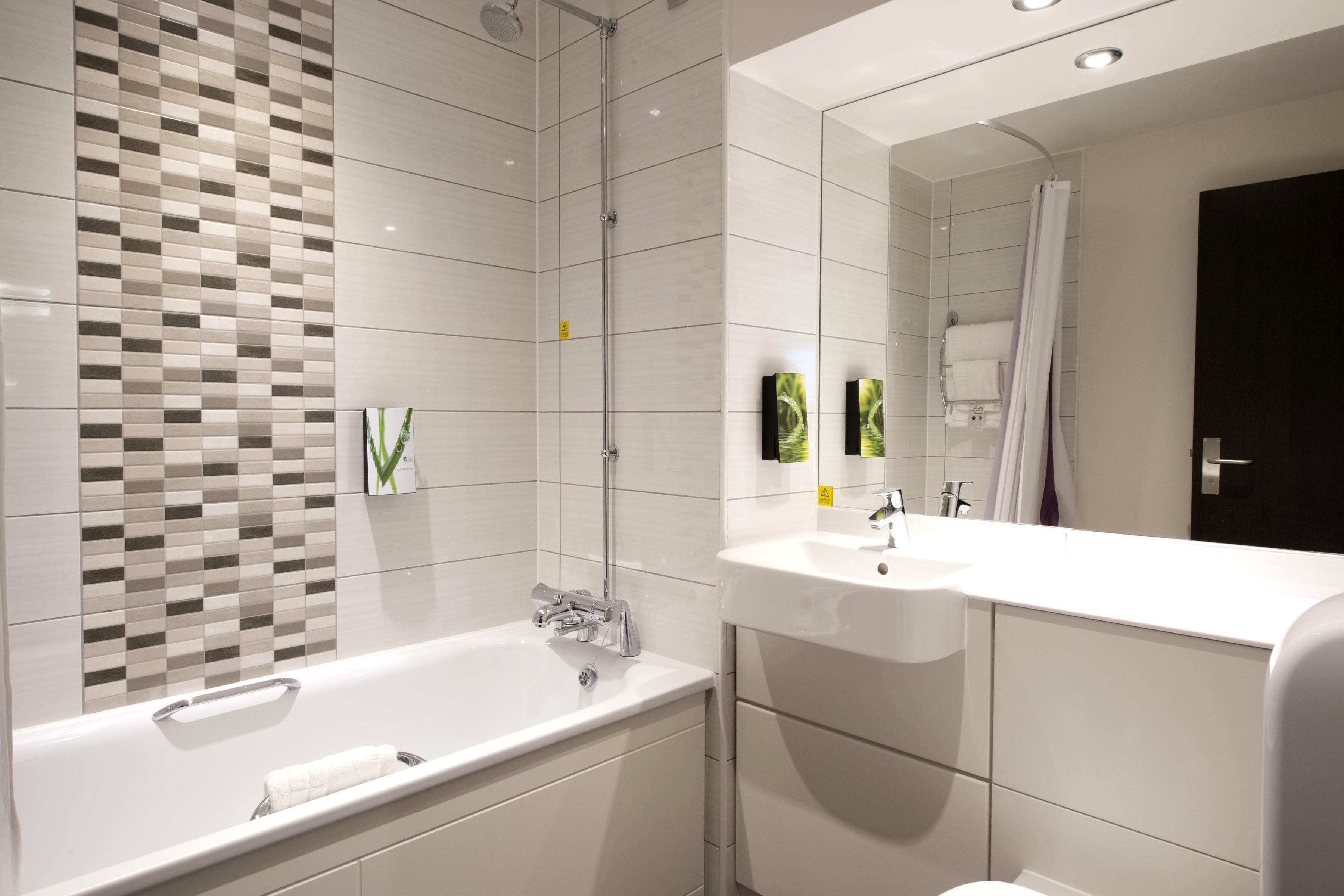 A modern bathroom with a large bathtub, a separate shower area, and a vanity with a sink.