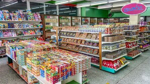 Un supermercado con estantes llenos de diferentes productos alimenticios y cajas de cereal.