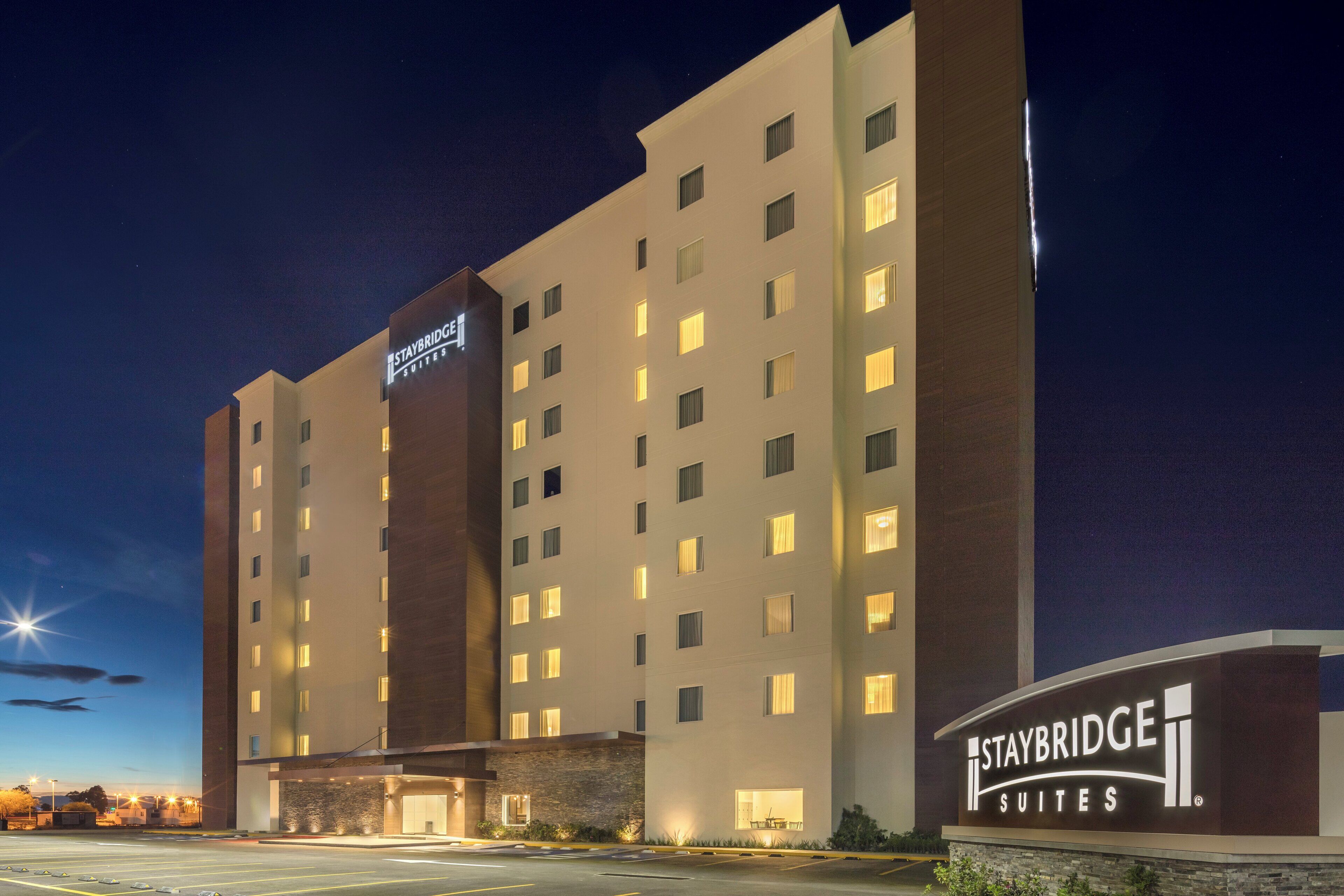 A multi-story hotel with a sign indicating 'Staybridge Suites.'