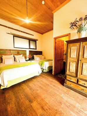 A room with two beds, wooden flooring, a large mirror, and a wooden wardrobe. - Hotel Boutique Casa Morasan (Quetzaltenango)