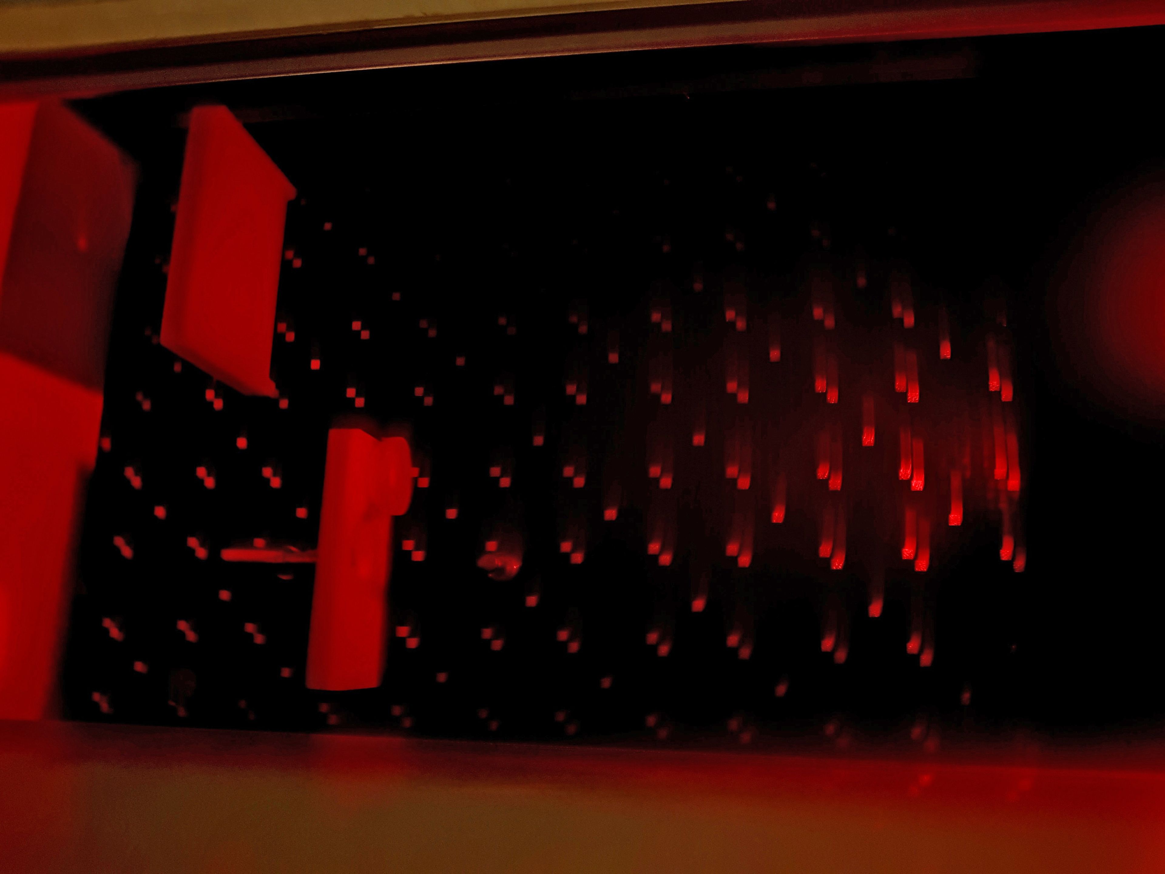 Un interior oscuro con iluminación roja y formas geométricas.