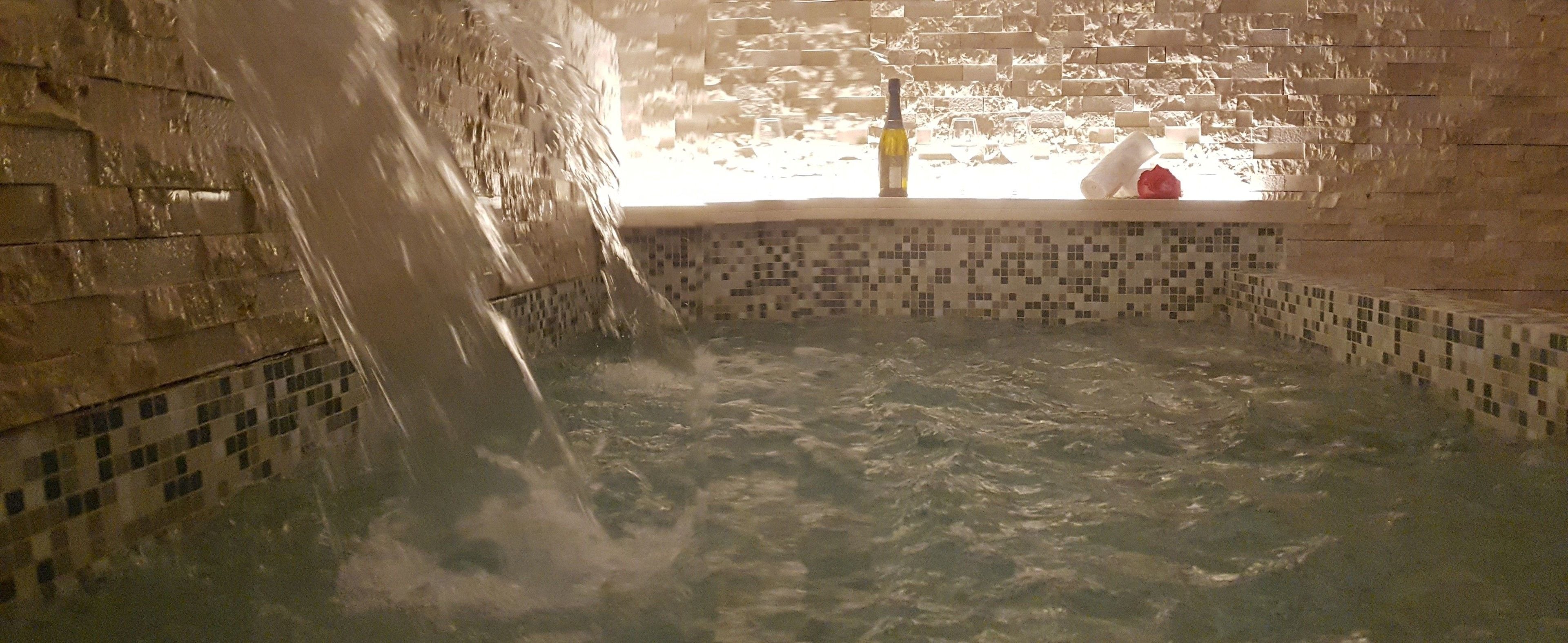 Un jacuzzi con interior de azulejos y pared de ladrillo.