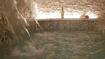 Un jacuzzi con interior de azulejos y pared de ladrillo.