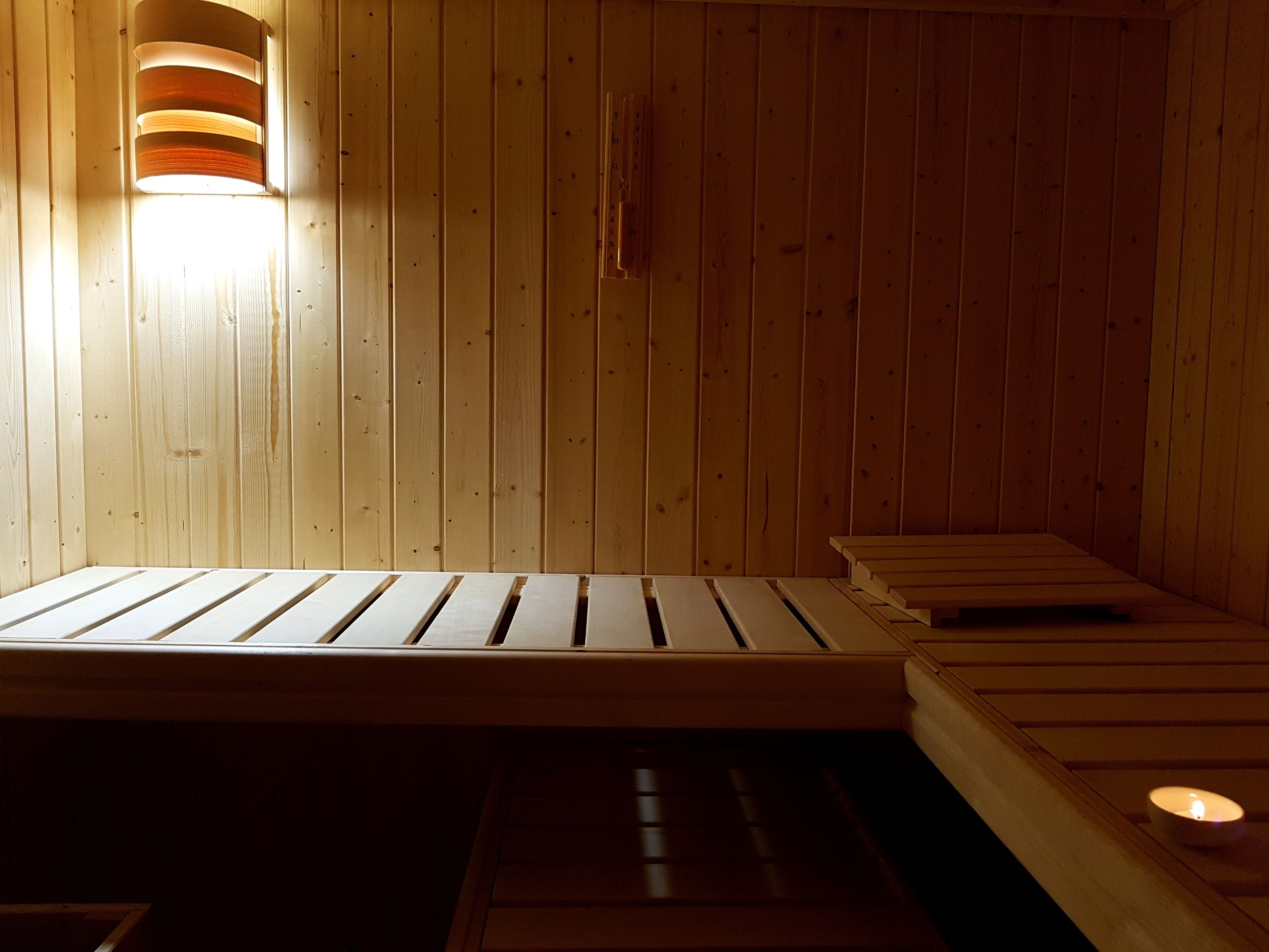 Eine Sauna mit Holzbänken und einer Wandleuchte.