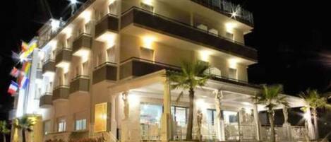 A multi-story hotel with balconies and a covered outdoor area.