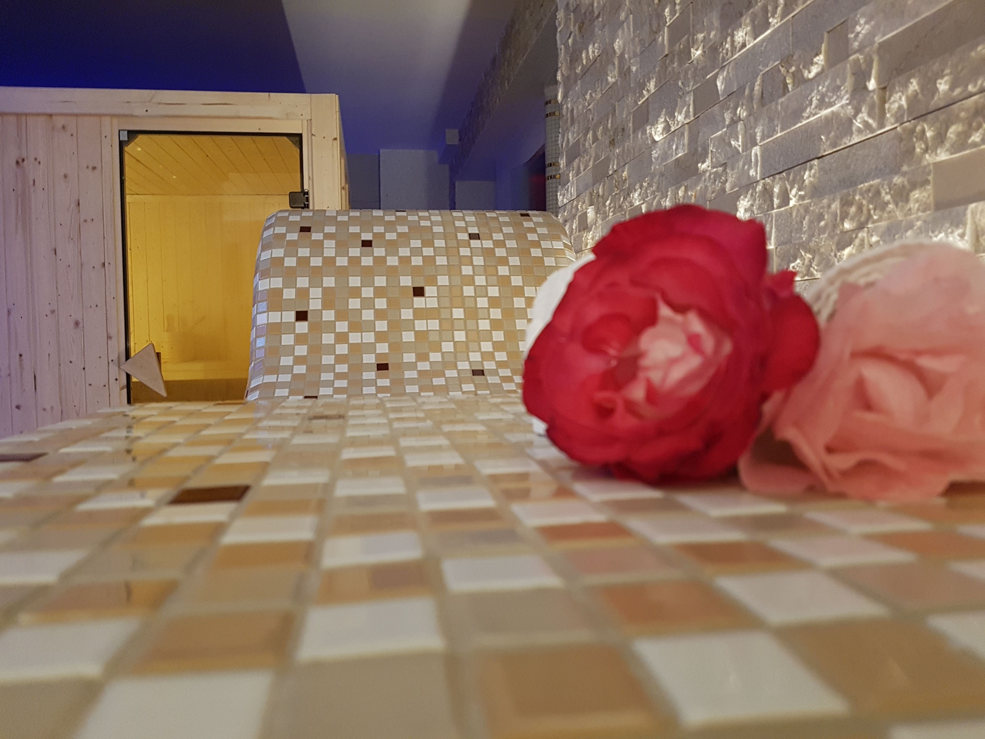 Une pièce avec un sol à carreaux, un mur à motifs et une porte en bois.
