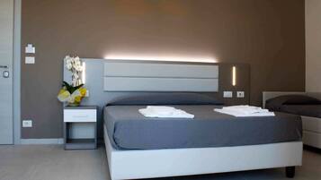 Une chambre moderne avec un lit, une table de chevet et un luminaire fixé au mur.