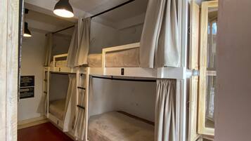 A bunk room with two bunk beds, a ceiling light, and a red floor.