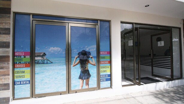 A hotel entrance with a large window displaying a tropical beach scene. - Hotel Select Inn Quinta Playa del Carmen (Playa del Carmen)