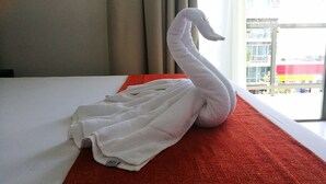 A bed with a white towel shaped like a swan placed on a red towel. - Hotel Select Inn Quinta Playa del Carmen (Playa del Carmen)
