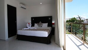 A hotel room with a large bed, a headboard, a nightstand, a red lamp, and a view of the outside balcony. - Hotel Select Inn Quinta Playa del Carmen (Playa del Carmen)
