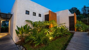 A modern building with a white facade, three windows, and a wooden deck. - Salento Pequeño Hotel (Salento)