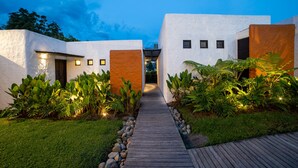 A pathway leading to a building with a modern design, surrounded by lush greenery and a clear sky. - Salento Pequeño Hotel (Salento)