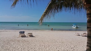 Nära stranden, vit sandstrand, parasoller och strandhanddukar