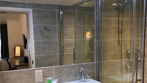 Une salle de bain moderne avec une douche à parois de verre, un lavabo blanc et des toilettes.