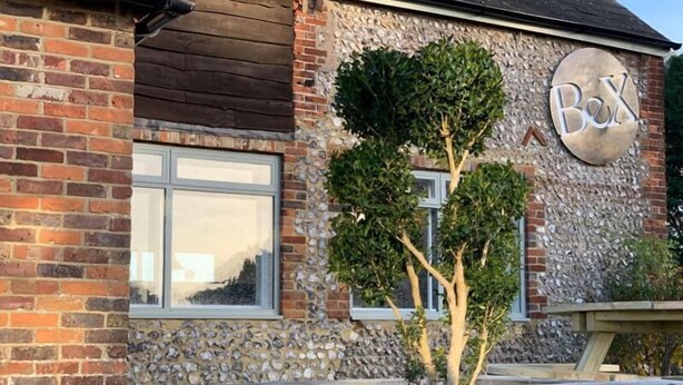 Un bâtiment en briques avec une façade en pierre et une enseigne sur laquelle on peut lire « B&X ».