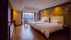 Un dormitorio amplio con una cama grande, una silla y vistas a las montañas a través de la ventana.